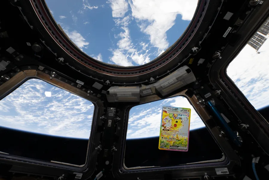 Foto do post oficial: a carta Pikachu ex 238/191 flutuando na Cupola da Estação Espacial Internacional